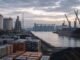 Oil tanks, metal ingots, coal, grain silos and an unmarked cargo ship at an industrial commodities port.