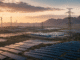Solar panels, wind turbines, battery storage and transmission lines across a renewable-energy landscape in China at sunrise.