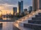 European financial district at dawn with stone steps, stacked papers and energy infrastructure symbolising higher interest rates and inflation pressure.