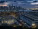 Singapore’s skyline, container port, data-centre infrastructure and an oil tanker at blue hour, illustrating technology-led growth alongside imported energy costs.