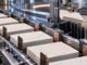 Blank bond certificates move through an orderly metal sorting system as one stack is selectively removed.